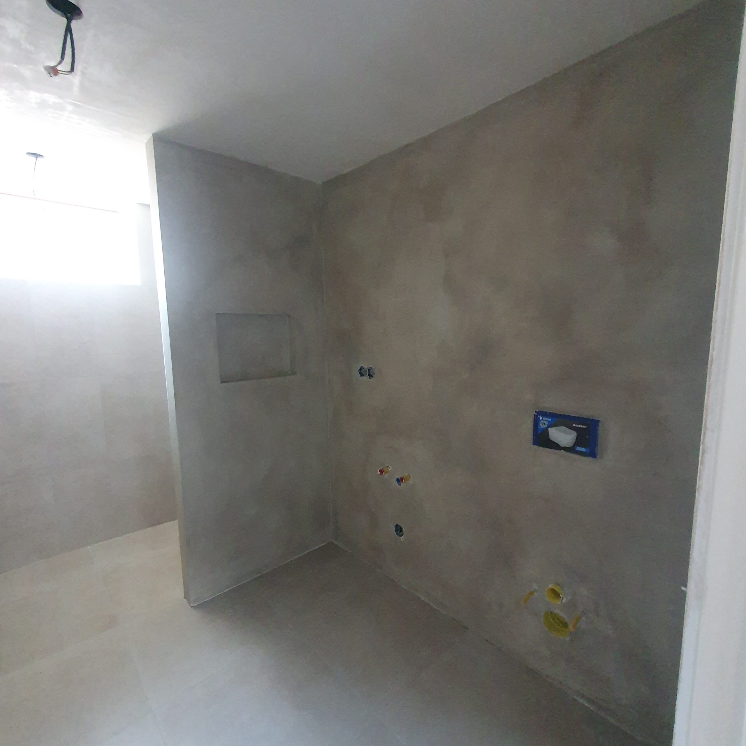 Renovatie badkamer met strak stucwerk en voorbereidingen voor sanitair